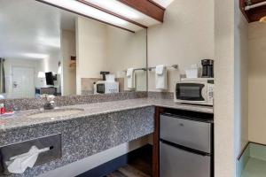 un baño de hotel con fregadero y microondas en Econo Lodge Portland Airport, en Portland