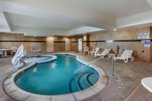 a hot tub in a hotel room with chairs and tables at Comfort Suites Plano - Dallas North in Plano