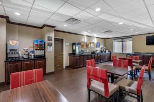 a dining room with tables and chairs and a bar at Comfort Suites Plano - Dallas North in Plano