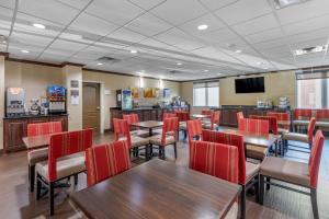 a restaurant with tables and chairs and a bar at Comfort Suites Plano - Dallas North in Plano