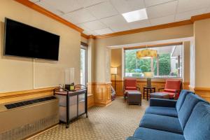 a waiting room with a blue couch and a flat screen tv at Comfort Inn Petersburg Near Fort Gregg-Adams in Petersburg