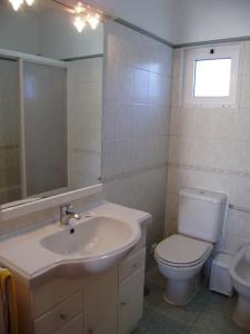 a bathroom with a sink and a toilet and a mirror at Villa Da Colina - front line villa over looking the beach and golf course in Vale Do Lobo in Vale do Lobo