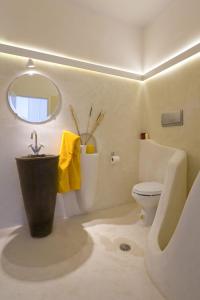 a bathroom with a sink and a toilet and a mirror at w Villa Black Rock Santorini in Akrotiri