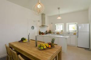 a kitchen with a wooden table with fruit on it at w Villa Black Rock Santorini in Akrotiri