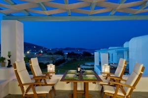 a dining room with a table and white chairs at Luxury Paros Villa 2 Bedrooms Villa Royalty Beautiful Sea Views & Private Terrace Naousa in Kampos Paros