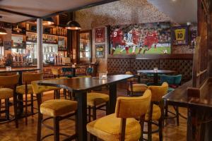 a bar with tables and chairs and a football mural at The Lord Street Hotel; BW Signature Collection in Southport