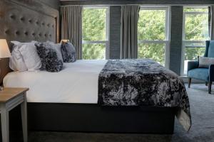 a bedroom with a large bed and two windows at The Lord Street Hotel; BW Signature Collection in Southport