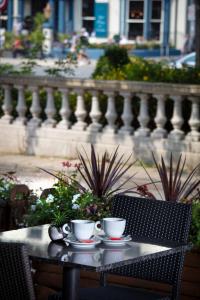 two cups of coffee sitting on a table in front of a fence at The Lord Street Hotel; BW Signature Collection in Southport