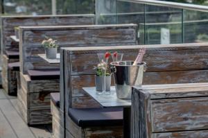 a row of wooden benches with plants in buckets at The Lord Street Hotel; BW Signature Collection in Southport