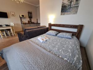 a bedroom with a bed and a couch at Apartament Starówka 6 in Toruń