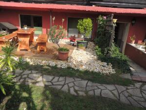 a backyard with a wooden deck with a table and bench at Ferienwohnung Am Hausberg in Radebeul in Radebeul