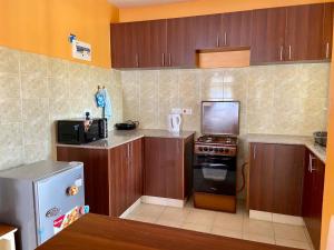 a kitchen with wooden cabinets and a stove top oven at Peach Apartment in Nairobi