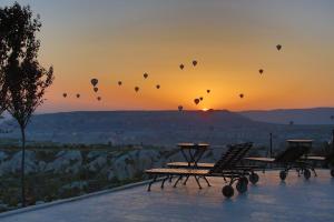un grupo de globos de aire caliente en el cielo al atardecer en Ariana Sustainable Luxury Lodge - Special Category - Cappadocia, en Uchisar