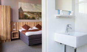 ein Bad mit einem Waschbecken und einem Sofa in einem Zimmer in der Unterkunft Hotel Asterisk, a family run hotel in Amsterdam