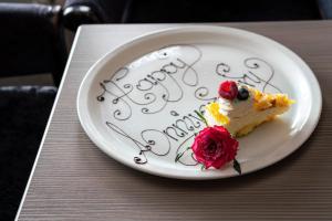 a piece of cake on a plate with the words happy birthday at The Lord Street Hotel; BW Signature Collection in Southport