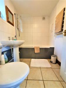 a bathroom with a sink and a toilet and a tub at The Coach House in Ruthin