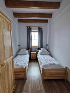 two twin beds in a room with a window at Apartamenty Stajnia Ojcowizna in Pokrzywnica