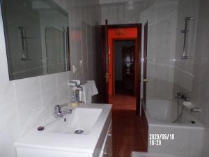 y baño con lavabo blanco y bañera. en Casa Concha, en Porto do Son