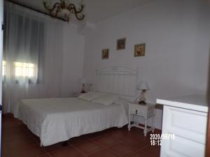 1 dormitorio con cama blanca, mesa y ventana en Casa Concha, en Porto do Son