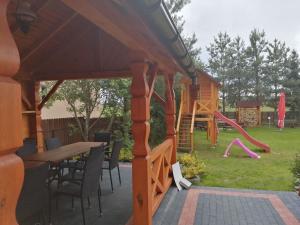 a pavilion with a table and chairs and a playground at Agroturystyka u Jarka in Bryzgiel