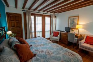 a bedroom with a bed and a desk and a television at Hotel Casa Palacio Uclés in Uclés