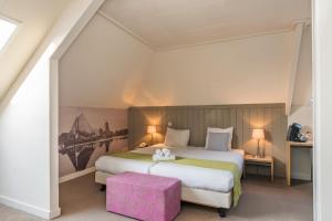 En eller flere senge i et værelse på Hotel Oostergoo