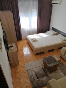 - un salon avec 2 lits et une table basse dans l'établissement Apartman dt Valjevo, à Valjevo