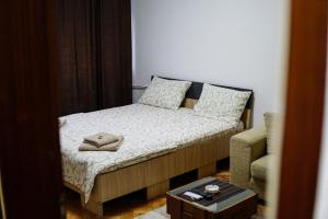 un piccolo letto in una stanza con un tavolo di Apartman dt Valjevo a Valjevo