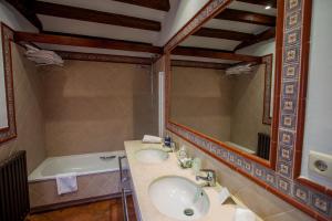 a bathroom with a sink and a tub and a mirror at Hotel Casa Palacio Uclés in Uclés +26 photos