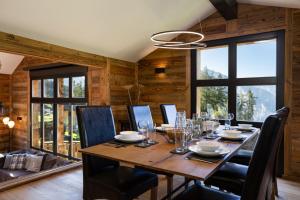 a dining room with a table and chairs and windows at Paradise Awaits in the Mountains of La Tzoumaz in La Tzoumaz