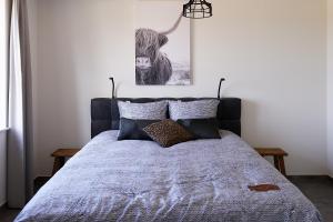 1 dormitorio con 1 cama con edredón azul en Hof Welzinge, en Ritthem