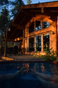 a log house with a pool in front of it at Puruvesi Holiday Villas, Kalliohovi in Hiukkajoki