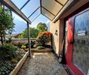 a red door of a house with a garden at Jobling's Holiday Apartment in Interlaken