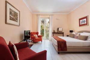 a bedroom with a bed and a couch and a chair at I Mori di Porta Nuova Suite & Terrace in Palermo