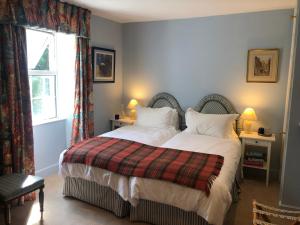 a bedroom with a bed with white sheets and a window at Hollamoor Farm in Barnstaple