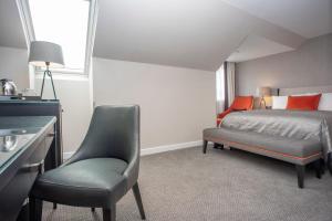 1 dormitorio con cama, silla y escritorio en Ten Hill Place en Edimburgo