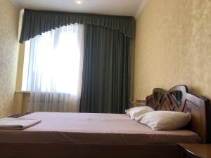 um quarto com uma cama e uma janela grande em Aparts on Savchenko 6B street em Dnipro