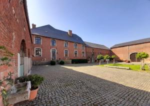 un cortile vuoto di un edificio in mattoni di Haras & Hotel Petit-Hallet a Hannut