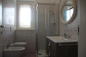 y baño con aseo, lavabo y espejo. en B&b Sogni d'oro Milena, en Civitanova Marche