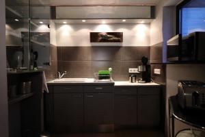 eine Küche mit schwarzen Schränken und einem Waschbecken darin in der Unterkunft Art of Living in Plön