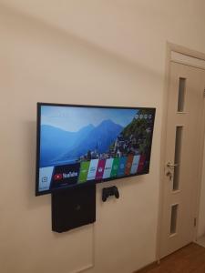einen Flachbild-TV, der an einer Wand hängt in der Unterkunft London Apartment, Odessa in Odessa