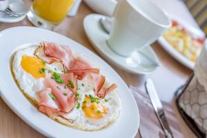 una bandeja de desayuno con huevos y tocino en una mesa en Appartementhaus Kathrin en Sölden