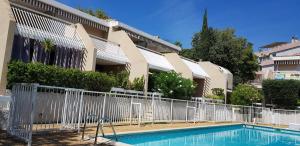una valla alrededor de una piscina frente a un edificio en "Côté Charlemagne" Centre-ville Garage Piscine Terrasse, en Cassis