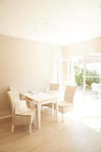 ein weißes Esszimmer mit einem weißen Tisch und Stühlen in der Unterkunft Ferienwohnungen Zum Goldenen Anker in Tönning