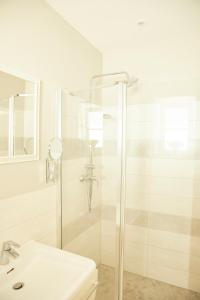 ein weißes Badezimmer mit Dusche und Waschbecken in der Unterkunft Ferienwohnungen Zum Goldenen Anker in Tönning + 24 Fotos