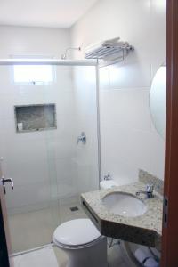a bathroom with a toilet a sink and a shower at Sudoeste Hotel in Goiânia