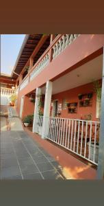 阿瓜斯－迪聖佩德羅的住宿－Piccola Pousada，粉红色的建筑,设有门廊和阳台