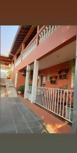 a pink building with a porch and a balcony at Piccola Pousada in Águas de São Pedro