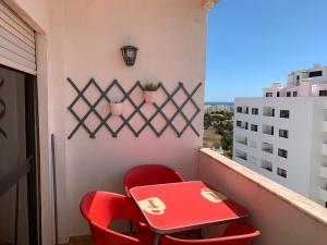 un tavolo rosso e sedie sul balcone di Apartamento 806 ad Albufeira