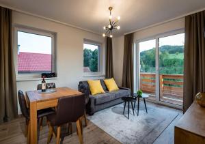 una sala de estar con un sofá y una mesa en Villa LiptovMara, en Ižipovce